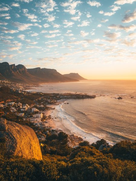 brown rocky mountain beside sea during daytime