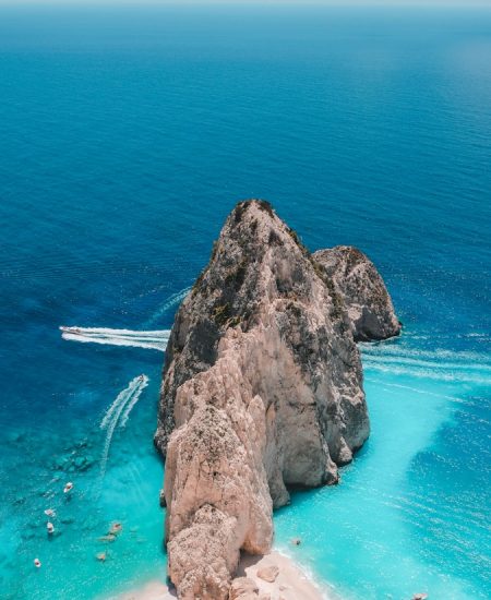 brown rock formation on body of water during daytime