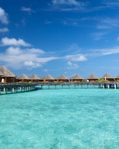 brown wooden house on blue water under blue sky during daytime