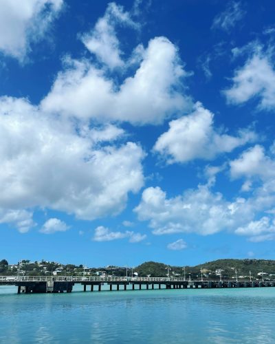 a bridge over a body of water under a cloudy blue sky