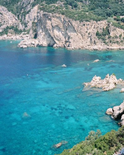 A boat floats in the turquoise sea.